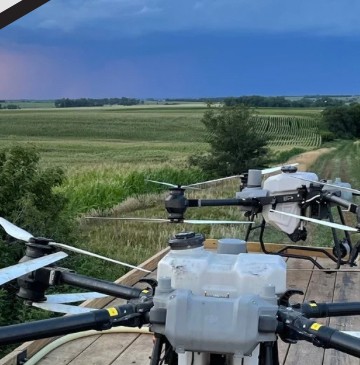 Agricultural spray drone on a trailer overlooking Midwest fields